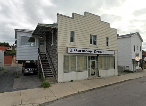 a white building with a sign that reads drop in