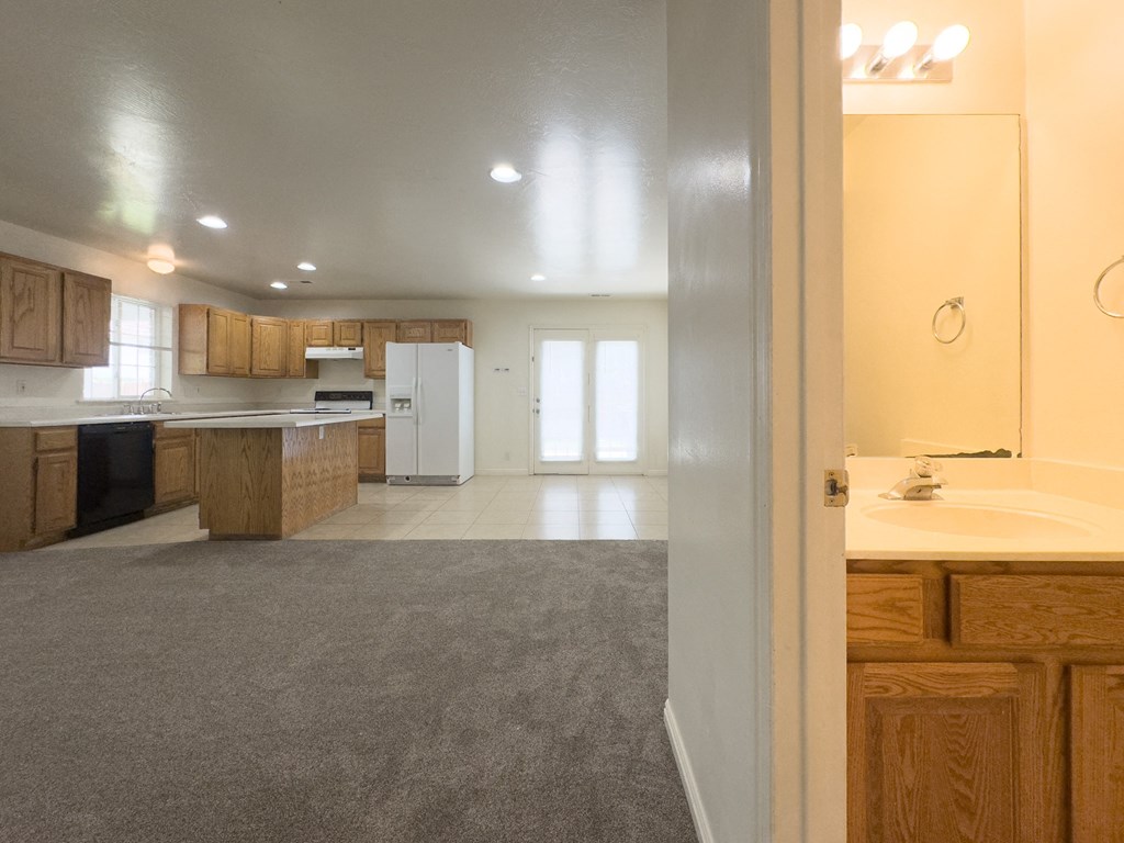 A kitchen with wooden cabinets and a white refrigerator.