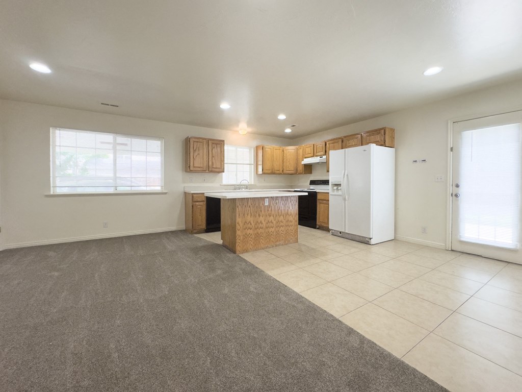 A kitchen with white appliances and wooden cabinets is shown.
