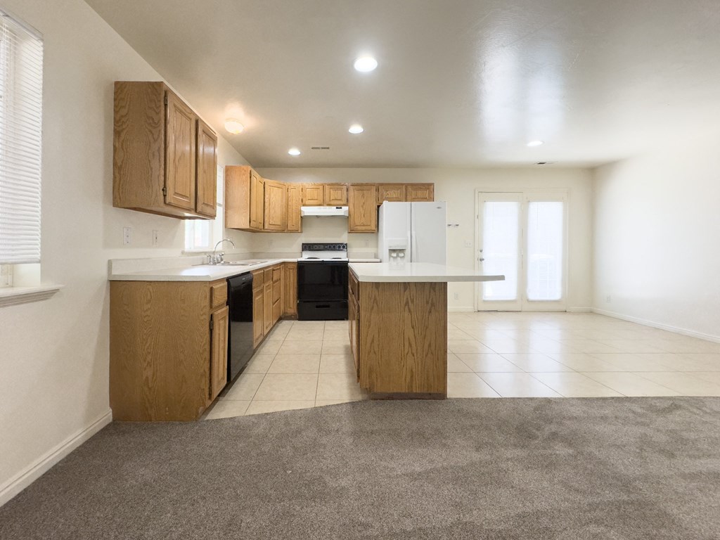 A kitchen with wooden cabinets and a white refrigerator.