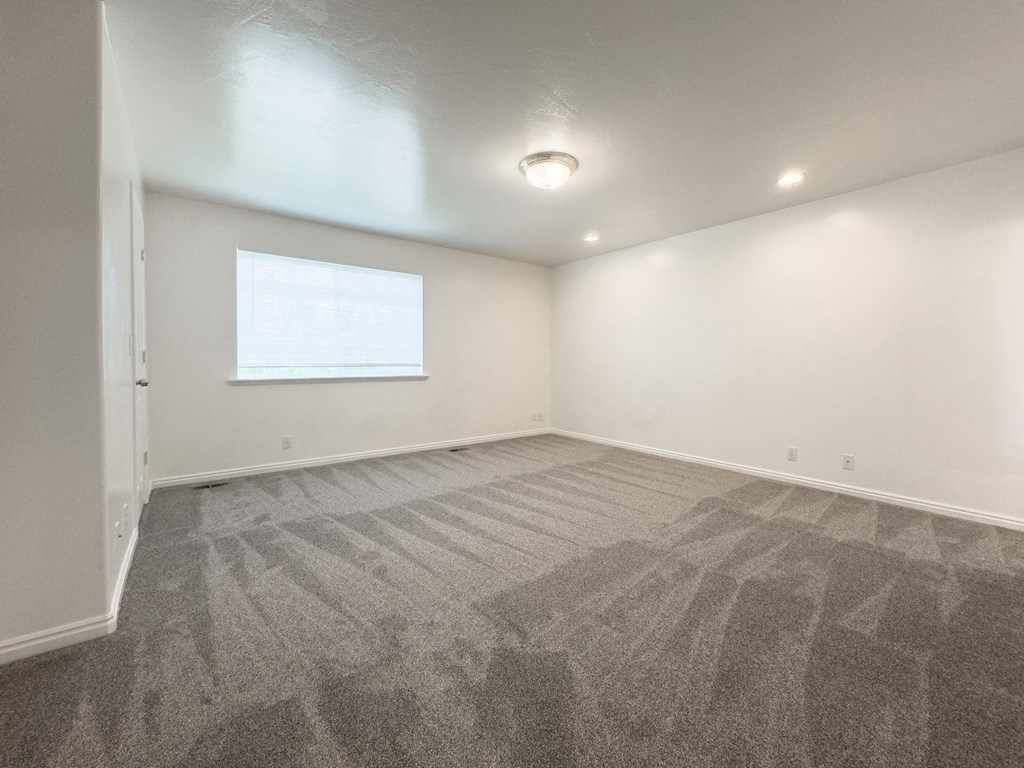 A room with a carpeted floor and a window.