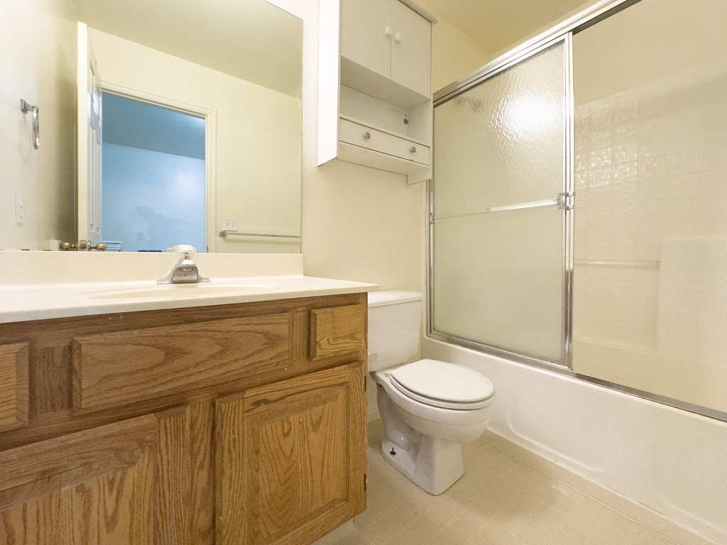 A bathroom with a toilet, sink, and shower.