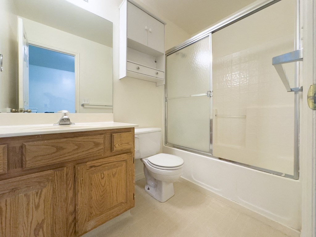 A bathroom with a toilet, sink, and shower.