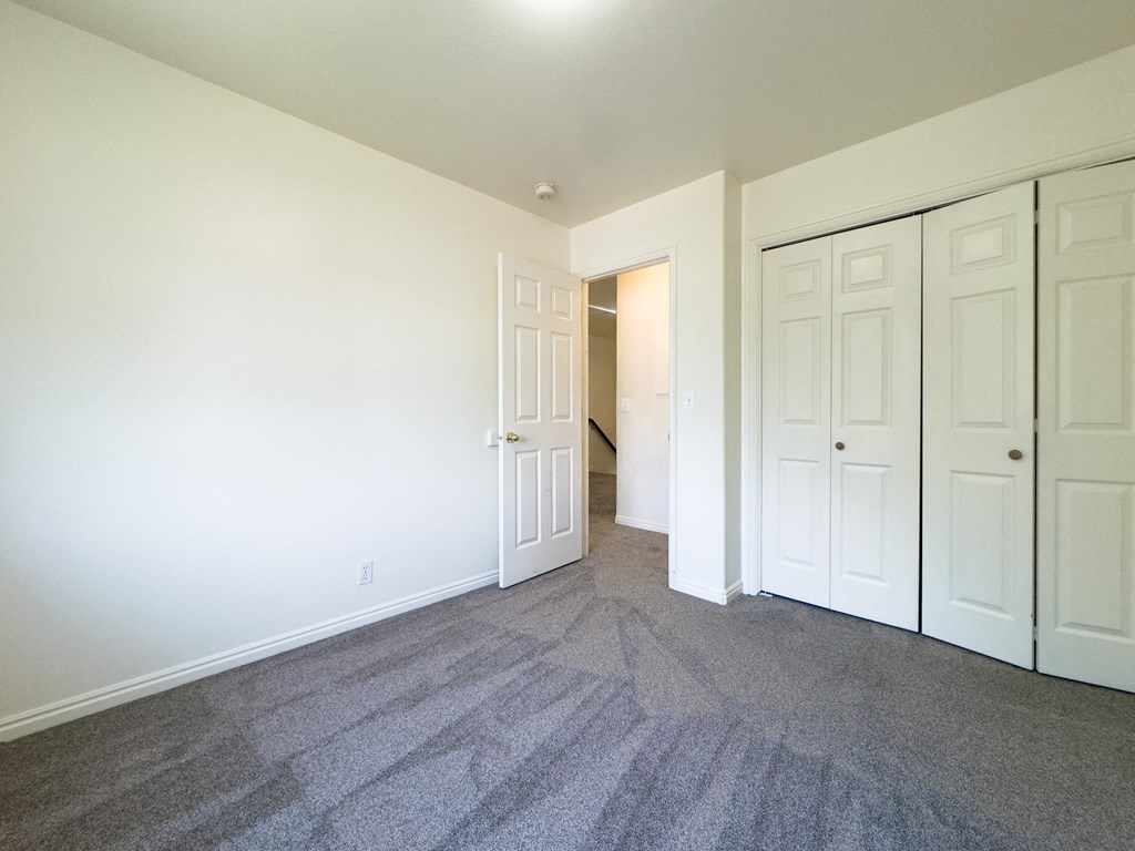 A room with a grey carpet and white walls.
