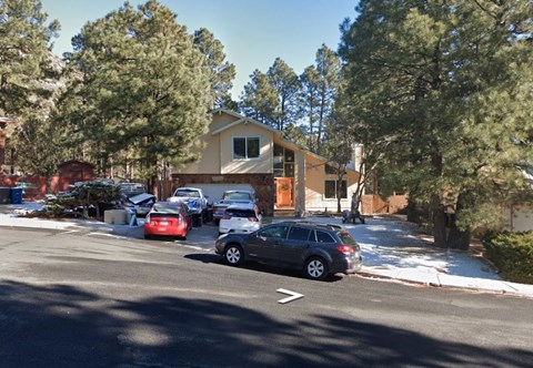 a house with cars parked in a parking lot