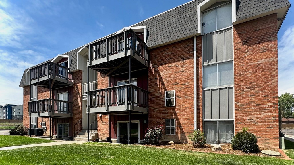 A red brick building with a balcony on the second floor.