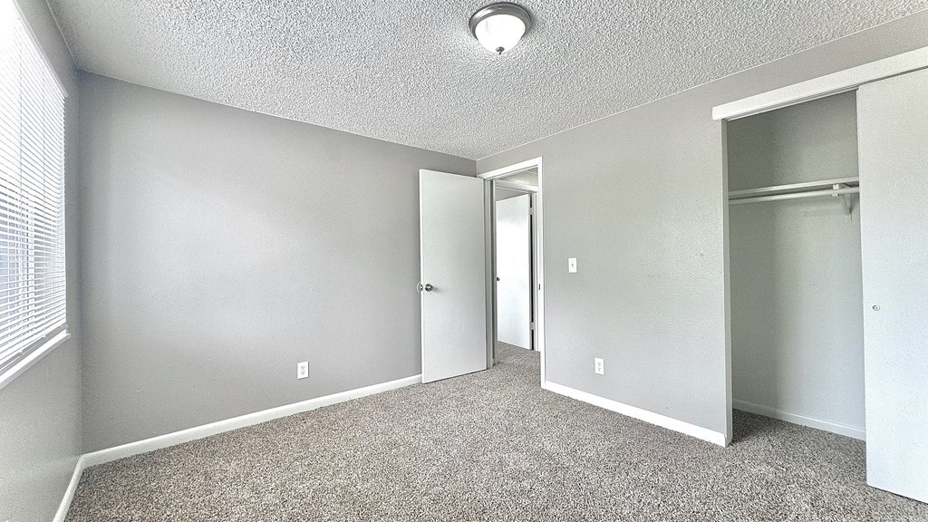 a wooden fence and gravel path in front of a brick building