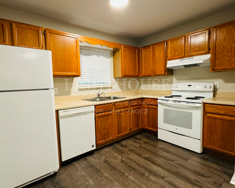 a kitchen with white appliances and wooden cabinets