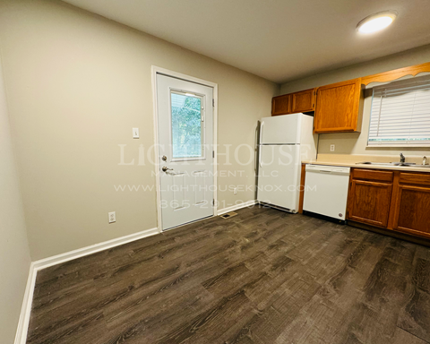 a kitchen with a refrigerator and a sink and a door