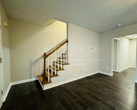 a stairwell in a home with wood floors and white walls