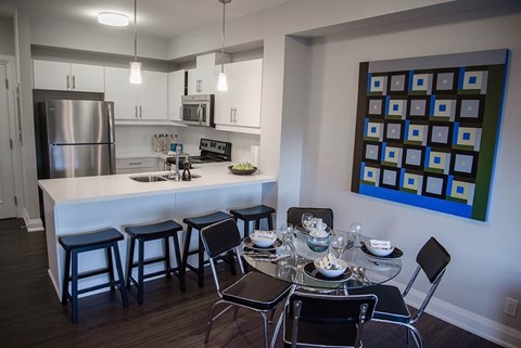 A modern kitchen with a dining table set for four.