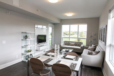 A modern dining room with a glass table and chairs.