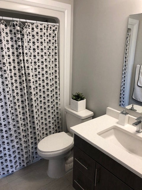 A white toilet sits next to a sink in a bathroom.