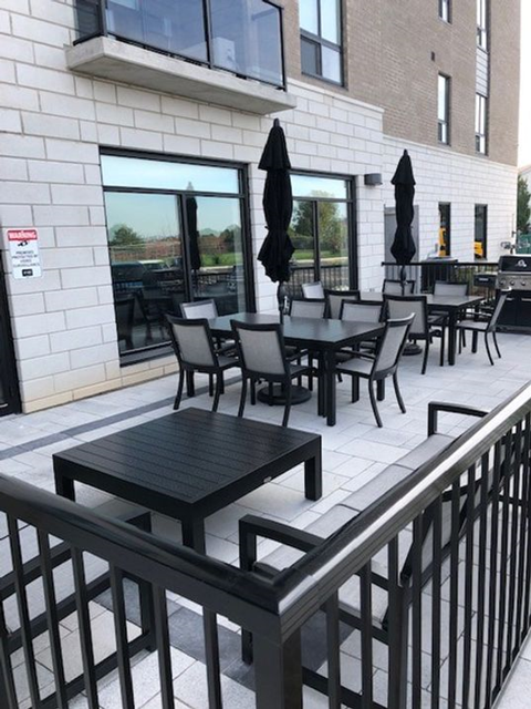 A black metal railing in front of a table and chairs.