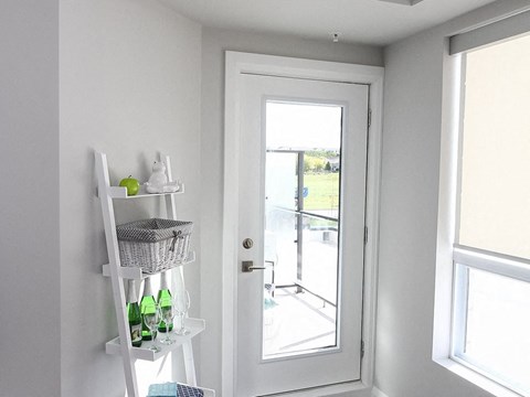 A white ladder with a basket on top is leaning against a wall next to a white door.