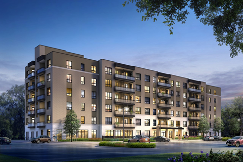 A modern apartment building with cars parked in front.