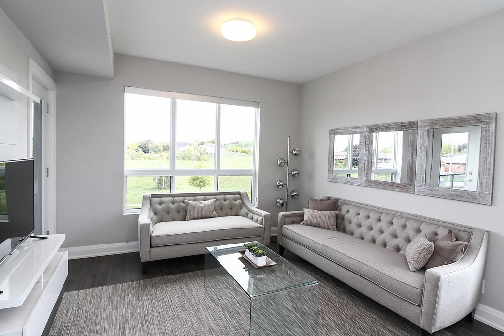 a living room with two couches and a glass coffee table
