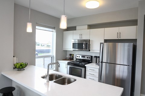 a kitchen with stainless steel appliances and a white counter top