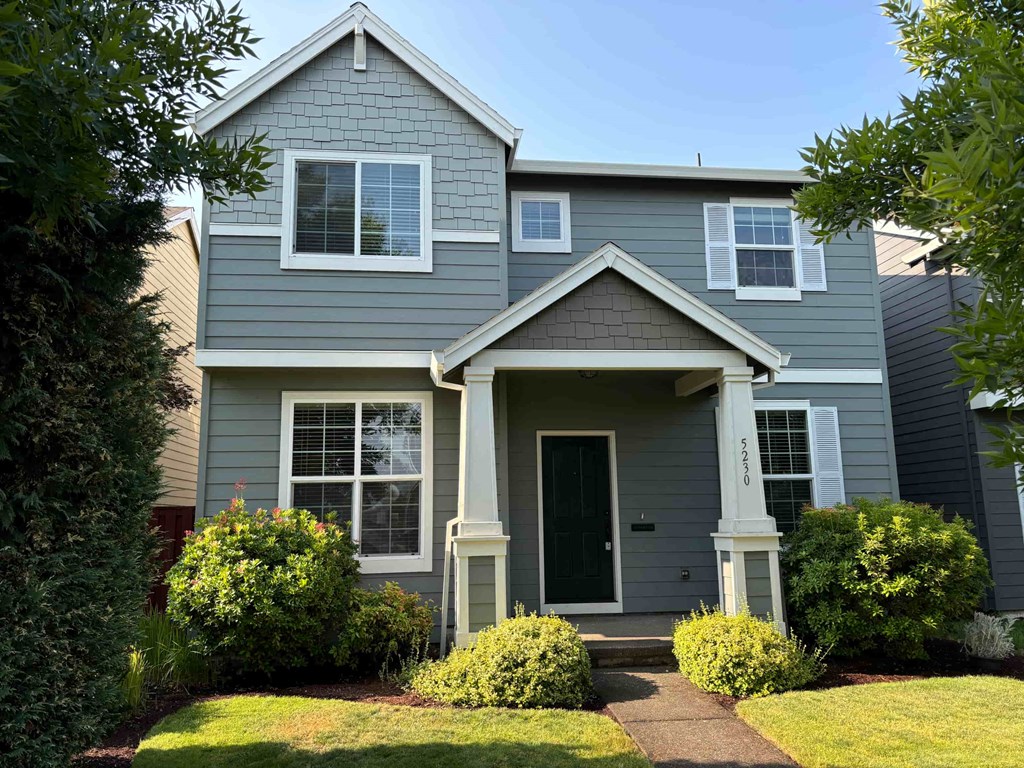 a blue house with white windows and a front yard