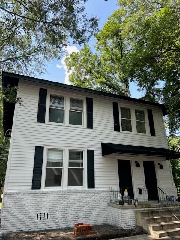 a white house with black shuttered windows