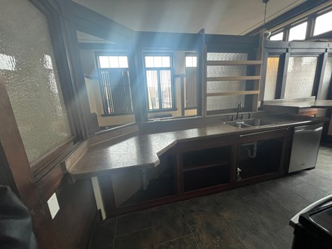 A kitchen with wooden cabinets and a large island with a sink.