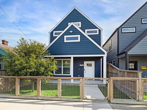 a blue house with a fence in front of it