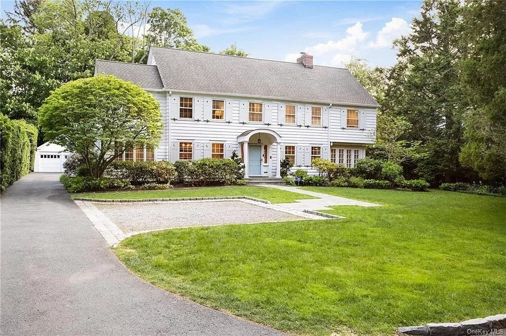 a white house with a driveway and a lawn