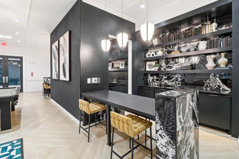 A black and white cafe with a long counter and stools.