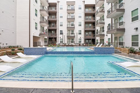 A swimming pool in front of apartment buildings.