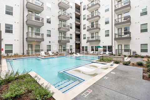 A swimming pool in front of apartment buildings.