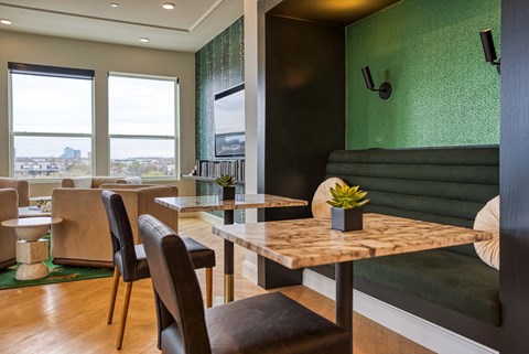 a dining room with tables and chairs and a green wall