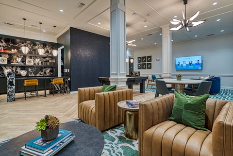 a lobby with couches and chairs and a table with a tv
