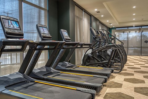 a row of treadmills in the gym of a hotel