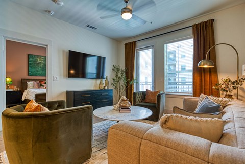 a living room with a couch and chairs and a tv