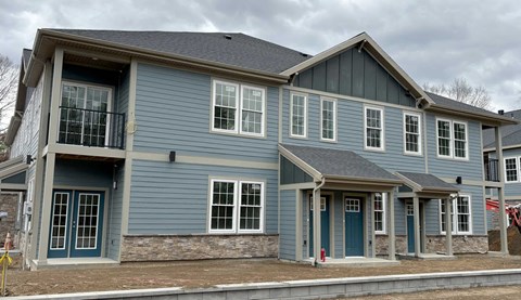 a blue house with a balcony and a street