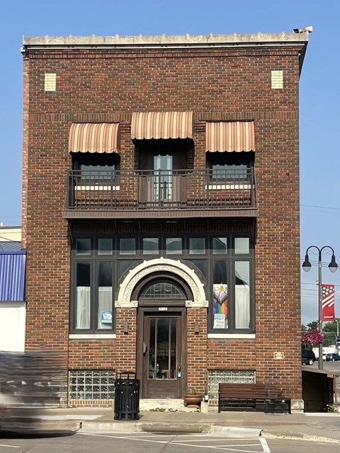 A red brick building with a balcony on the second floor.