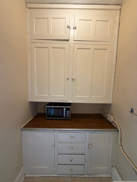 A microwave is sitting on a countertop in a kitchen.