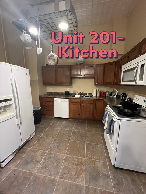 A kitchen with brown cabinets and a white fridge.