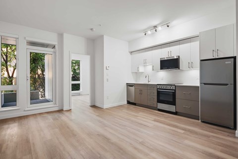 A kitchen with a refrigerator, oven, and microwave.