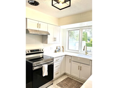 A kitchen with a black stove top oven and white cabinets.