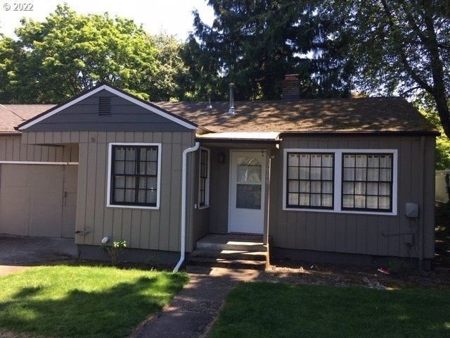 A small house with a white door and two windows.