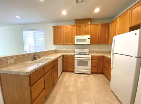 A kitchen with wooden cabinets and a white refrigerator.