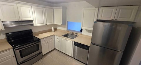 A kitchen with white cabinets and stainless steel appliances.