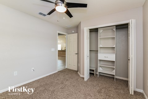 a bedroom with a closet and a ceiling fan