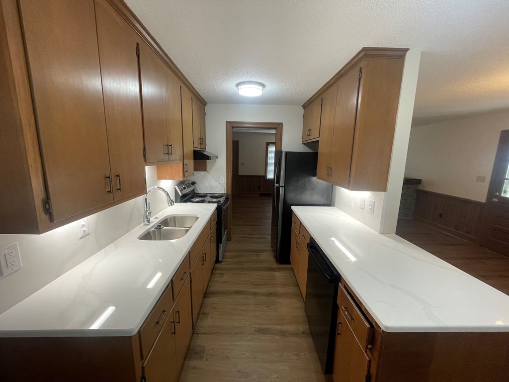 a kitchen with white counter tops and wooden cabinets