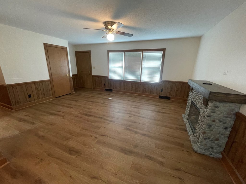 an empty living room with wood floors and a fireplace