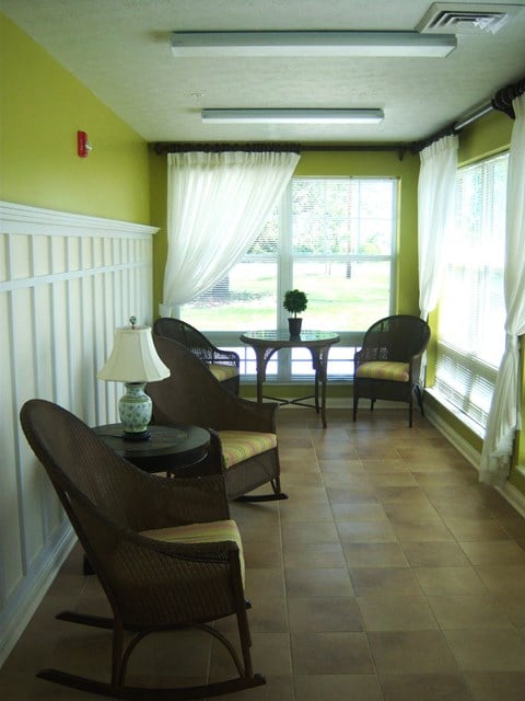 a living room with a table and chairs and a large window