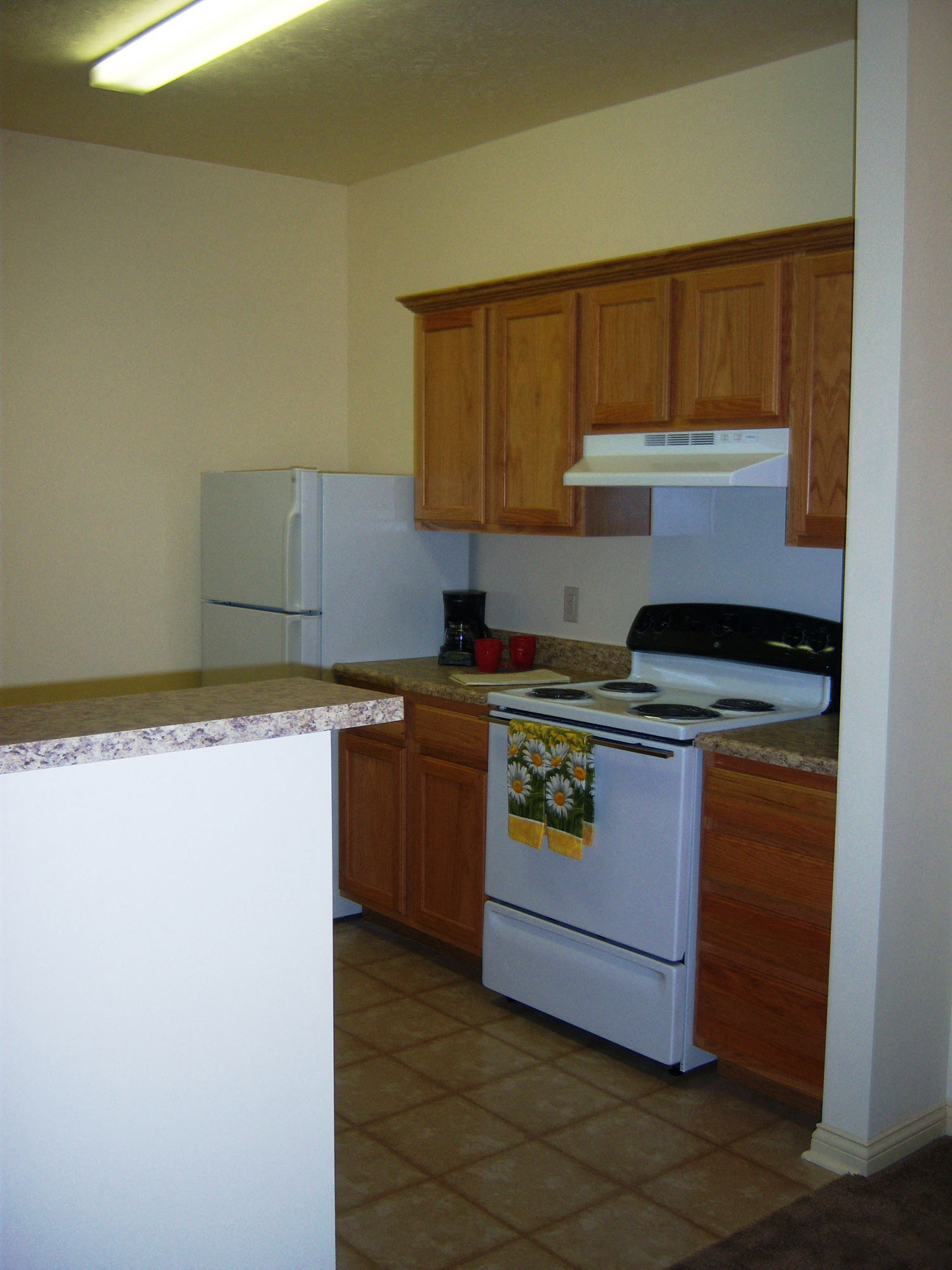 Kitchen, solid surface countertops, white appliances, tile flooring