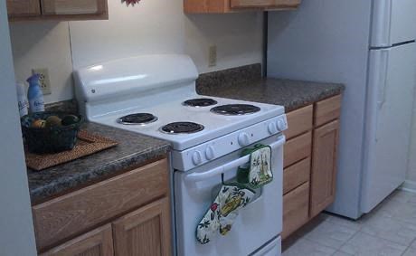 Kitchen, solid surface countertops, white appliances, tile flooring