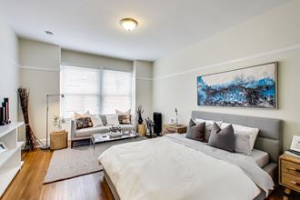 a white bedroom with a large bed and a couch